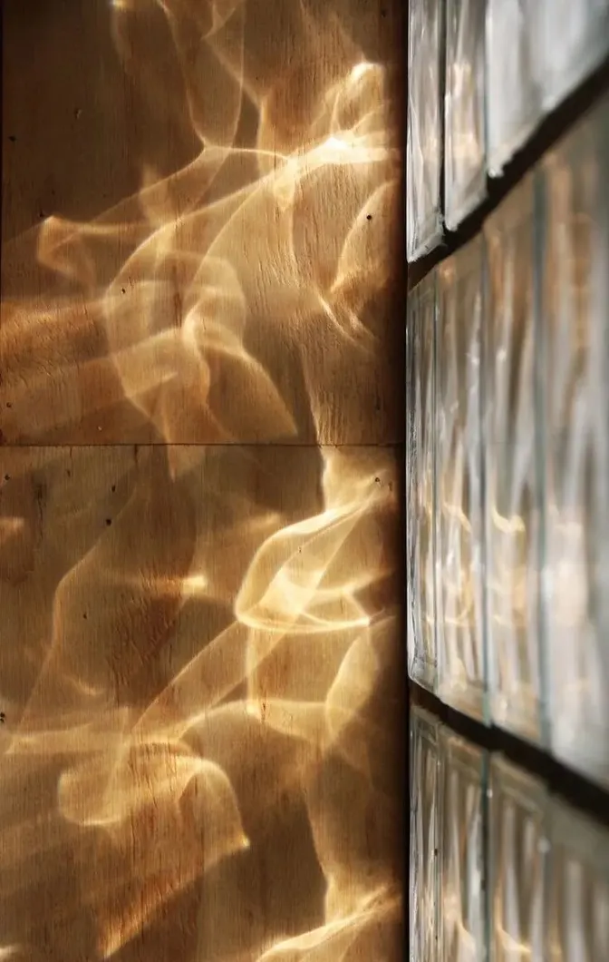 Light playing on a wooden wall through glass bricks